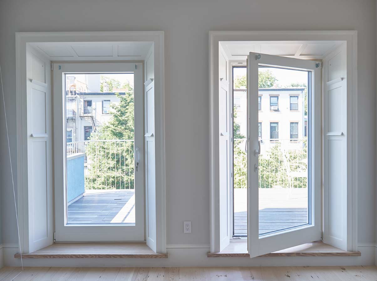 Puerta batiente hogar con vista exterior hacia otras casas